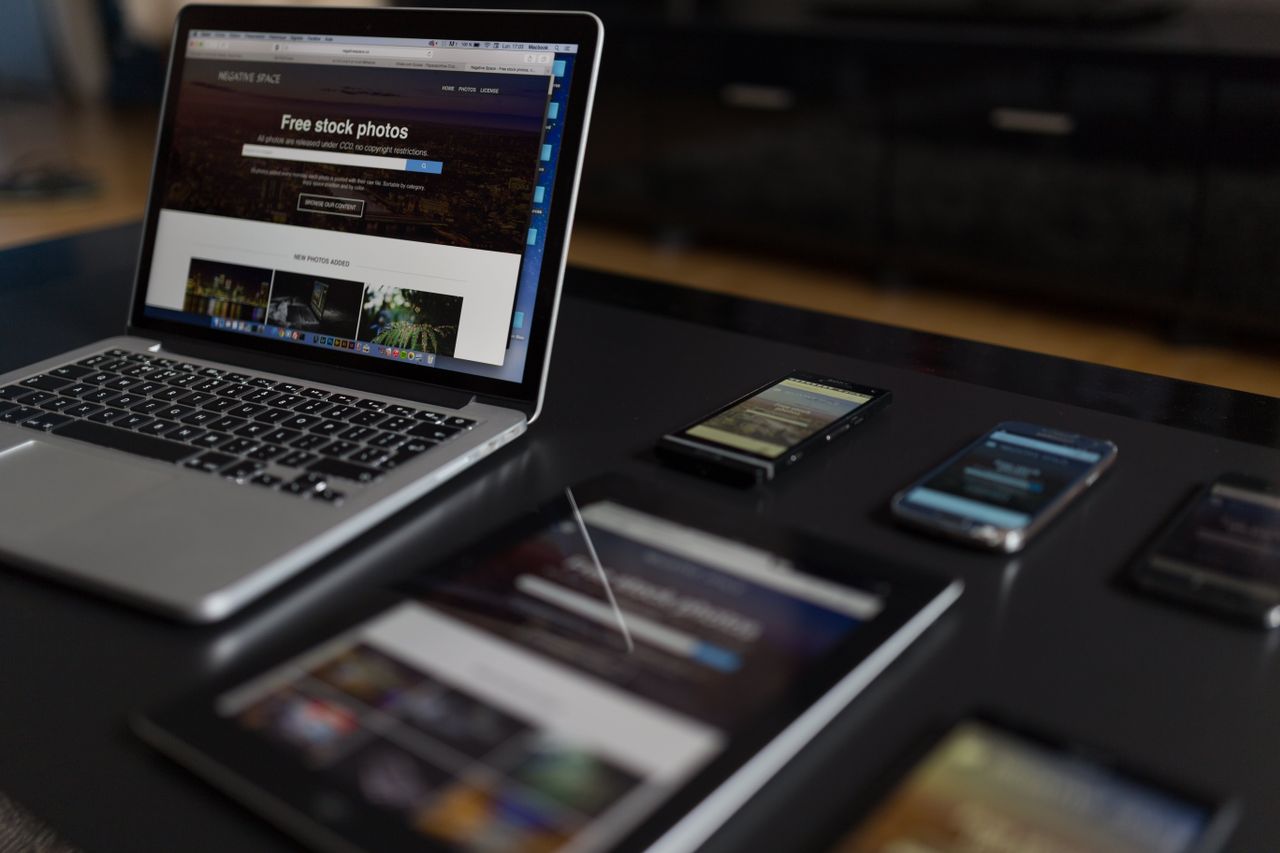 Un espace de travail contemporain avec un ordinateur portable, une tablette et des smartphones, idéal pour un usage tech et freelance.